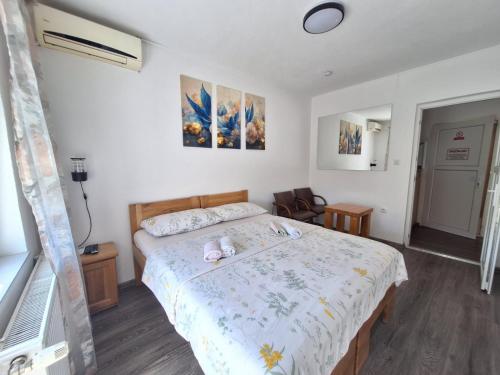 a bedroom with a bed with two stuffed animals on it at Sobe-Apartmani Modriča in Modriča