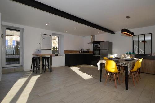 une cuisine et une salle à manger avec des chaises jaunes et une table dans l'établissement Gite Cour du Bourg - Baie du Mont Saint Michel, à Cherrueix