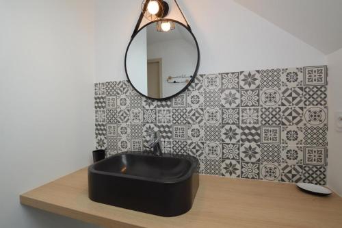 a bathroom with a black sink and a mirror at Gite Cour du Bourg - Baie du Mont Saint Michel in Cherrueix