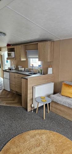 a kitchen with a couch and a table in a room at Bittern 22, Parkdean, California Cliffs, Scratby, sleeps 6, free wi-fi, bedding and towels included, 5 mins from beach in Great Yarmouth