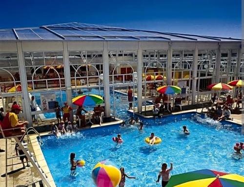 a group of people in a swimming pool with umbrellas at Bittern 22, Parkdean, California Cliffs, Scratby, sleeps 6, free wi-fi, bedding and towels included, 5 mins from beach in Great Yarmouth