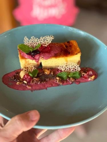 a person holding a piece of cake on a blue plate at Sunny Rose Bungalows Gili Air - Adults only in Gili Air