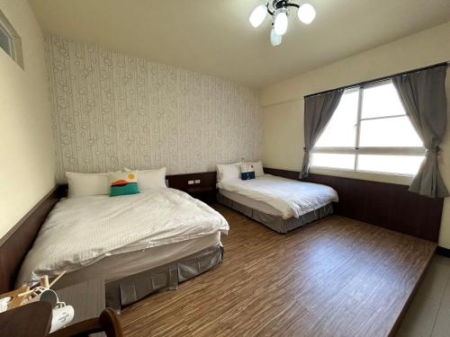 a bedroom with two beds and a window in it at 回家浪 in Hengchun