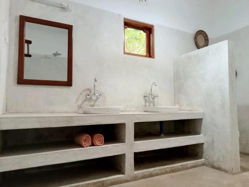 a bathroom with two sinks and a mirror at Peace and Love Garden in Mto wa Mbu