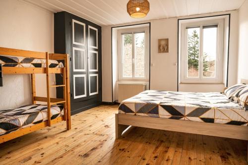 a bedroom with two bunk beds and two windows at Bienvenue chez vous ! in LʼEstrade