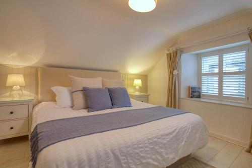 a bedroom with a large bed and a window at Grade II Listed Cottage Gorran Haven Sea Views in Gorran Haven