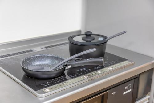 a pot and pans on top of a stove at Shirahama White Beach House - Self Check-In Only in Shirahama