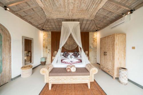 a bedroom with a bed with a mosquito net at Legong Sebatu Villa in Ubud