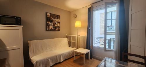 une petite pièce avec un lit et une fenêtre dans l'établissement Studio 103 Bail mobilité - Appartement pour voyages d'affaires et d'études, à Paris