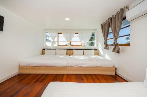 a bedroom with a bed and two windows at ON THE BEACH Beach Front in Ban Tha Sai