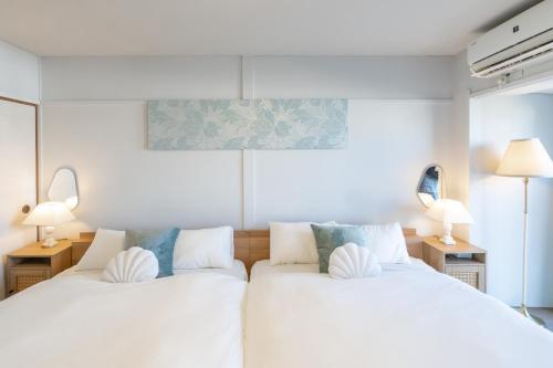 two white beds in a room with two lamps at Shirahama White Beach House - Self Check-In Only in Shirahama