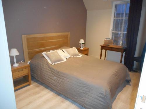 een slaapkamer met een bed met 2 nachtkastjes en een raam bij Aux Cottages du port Honfleur in Honfleur