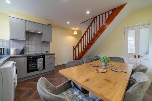 a kitchen and dining room with a wooden table and chairs at Beautiful Three Bedroom House - Manchester Escape in Manchester