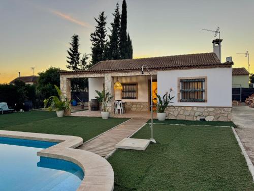 a house with a swimming pool in front of a house at Can Pines in Paradas