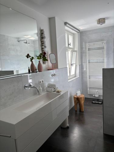 a white bathroom with a sink and a mirror at Haus ROSENSTEIN in Sassnitz