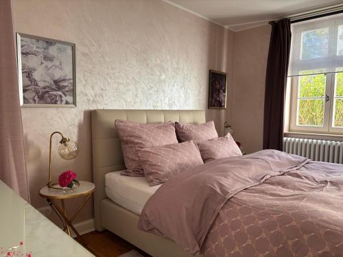 a bedroom with a bed with pink pillows and a window at Haus ROSENSTEIN in Sassnitz