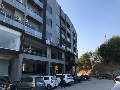 ein großes Gebäude mit auf einem Parkplatz abgestellten Autos in der Unterkunft Lavish 1BHK Apartment in Rawalpindi