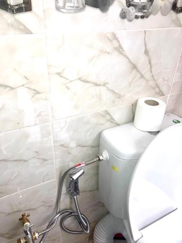 a bathroom with a white toilet with a roll of toilet paper at DarnA in Inezgane
