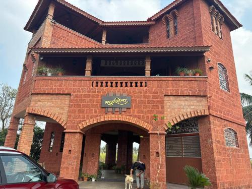 a building with a dog standing in front of it at Madhushilp farmstay in Sangli