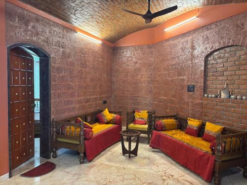a room with two beds and a brick wall at Madhushilp farmstay in Sangli