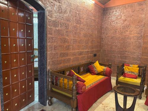 a room with two beds and a brick wall at Madhushilp farmstay in Sangli