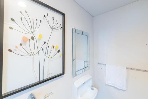a bathroom with a picture of flowers on the wall at Shirahama White Beach House - Self Check-In Only in Shirahama