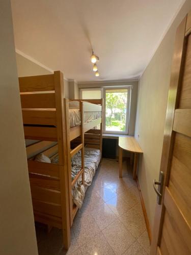 a small room with bunk beds and a window at Apartament Kołobrzeg in Kołobrzeg