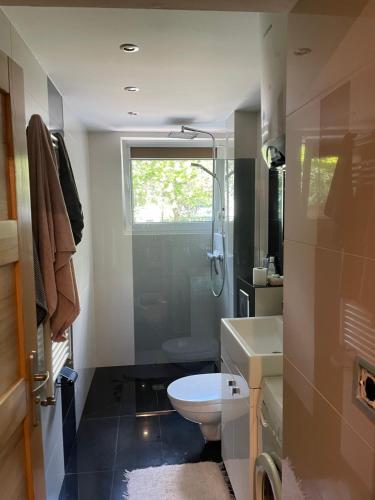 a bathroom with a toilet and a shower and a sink at Apartament Kołobrzeg in Kołobrzeg