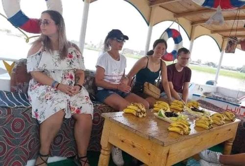 a group of people sitting around a table with bananas at Grand Square Hostel Luxor in Luxor