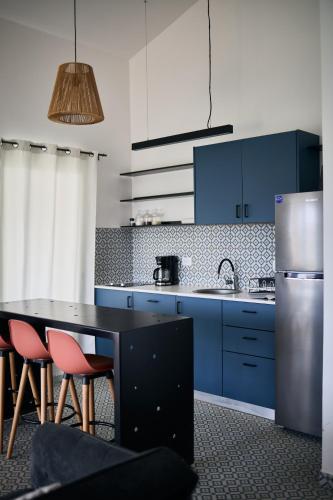 a kitchen with blue cabinets and a table and chairs at Homz Venao in Playa Venao