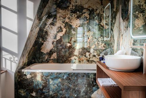 une salle de bain avec une baignoire et un lavabo dans l'établissement Hôtel Anne de Bretagne, à Saint-Malo