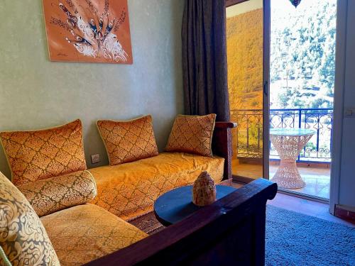 a living room with a couch and a large window at Kasbah Tifirte Grand Vallet in Ourika