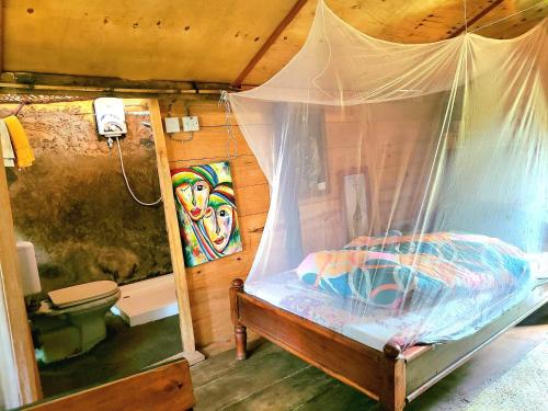 een slaapkamer met een bed met een klamboe bij Aroma Home - Eco-Cabins on a Coffee Farm in Arusha