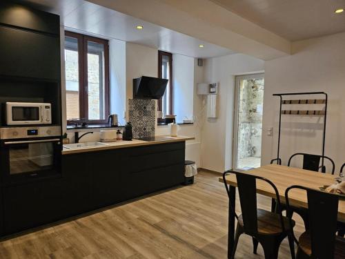 kuchnia i jadalnia ze stołem i kuchenką mikrofalową w obiekcie Chez Mamie Café w mieście Mouzon