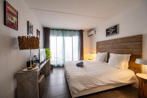 a bedroom with a large bed with a wooden headboard at Mango Chik Meublé Classé 2 étoiles ! in Saint-François