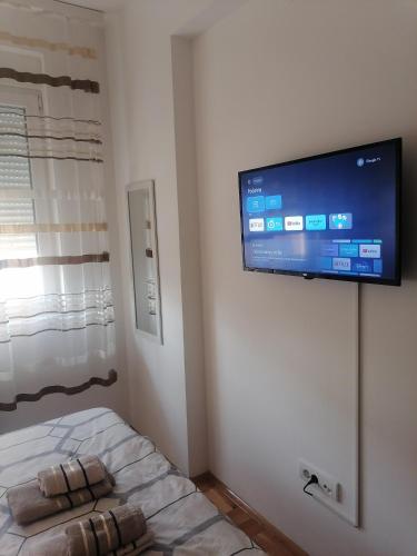 a bedroom with a flat screen tv on the wall at Apartman Zapadni Kej Pirot in Pirot