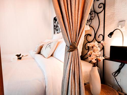 - une chambre avec un lit et un rideau dans l'établissement Rustic Charm&Dreamhome 40m2 in the heart of Paris, near Pompidou and Notre-Dame, Subway 4,8,9 Honeymoon favourite, à Paris