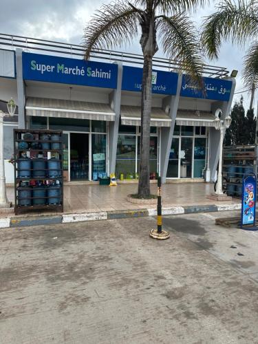 a store front with a palm tree in front of it at Tamaris Résidence les jardins Apparemment haut standing moderne et élégant 77 m in Casablanca
