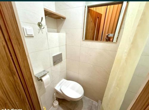 um banheiro branco com um vaso sanitário e um espelho em Night Host Krakowska 3 przy Rynku free parking em Bytom