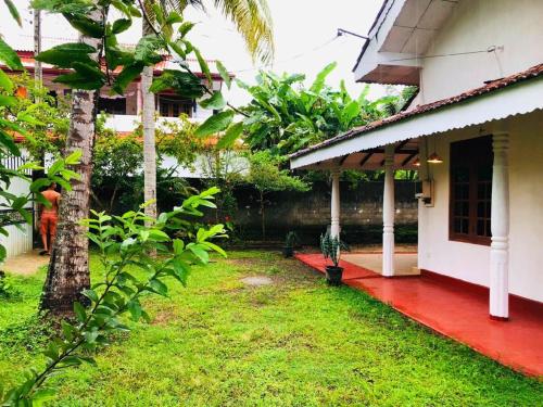 a house with a red floor and a yard at Relaxatation at Room Mirissa in Mirissa