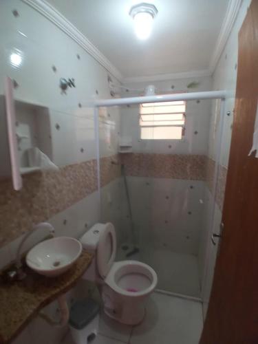 a bathroom with a toilet and a sink and a shower at Pousada Iguape Apartamentos - Ilha Comprida in Ilha Comprida