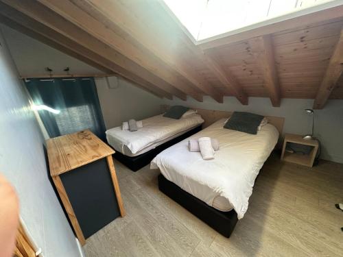 two beds in a room with a attic at MAISON DES VIGNES- TROQUAÏROU et BECCA MOTTA in Brides-les-Bains