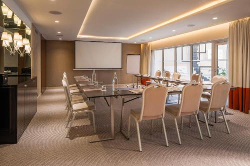 a conference room with a long table and chairs at Hôtel Le M in Paris