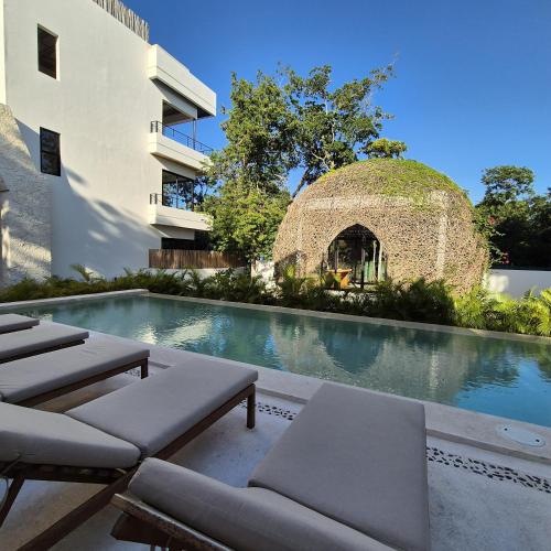 a swimming pool next to a building at New luxury studio with plunge pool in Tulum
