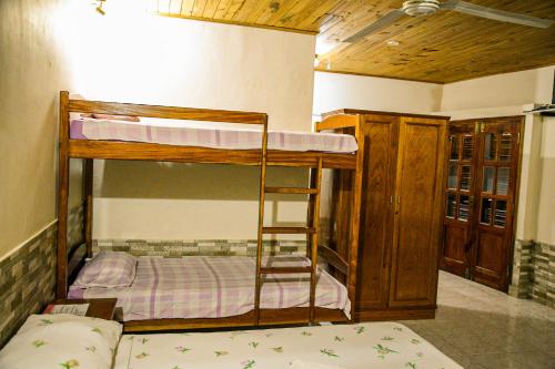 a room with two bunk beds and a ladder at Hotel Sport Camping in Independencia