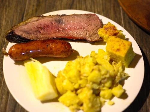 a plate of food with meat and eggs and potatoes at Hotel Sport Camping in Independencia