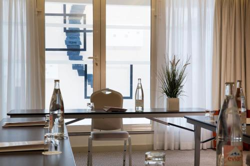a table with bottles on it in front of a window at Hôtel Le M in Paris