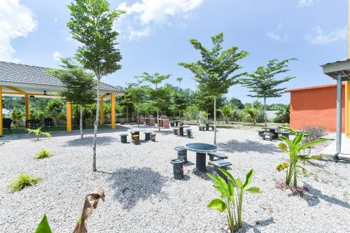 a playground with tables and trees in a park at Mersing Pelangi Beach Resort in Mersing