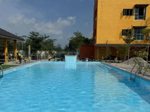 a large blue swimming pool next to a building at Mersing Pelangi Beach Resort in Mersing
