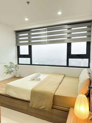 a bedroom with a large bed with a window at Hue Charm Apartment with Pool and Gym in Thôn Văn Dương